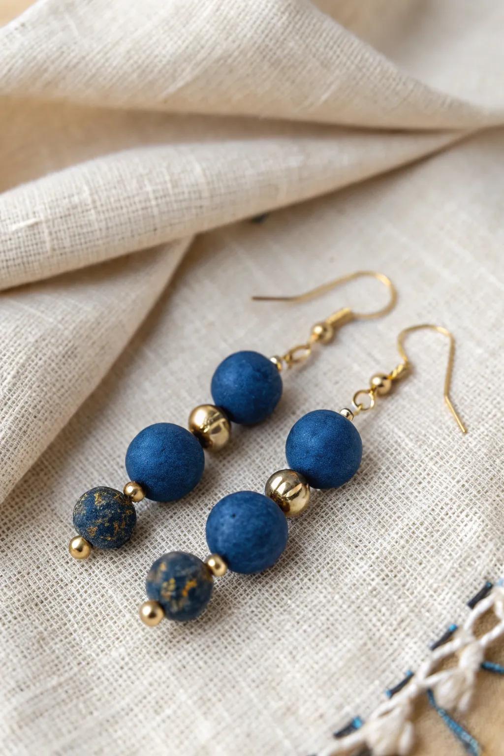 Enhance your elegance with these striking clay bead earrings, where deep blue meets golden glamour!
